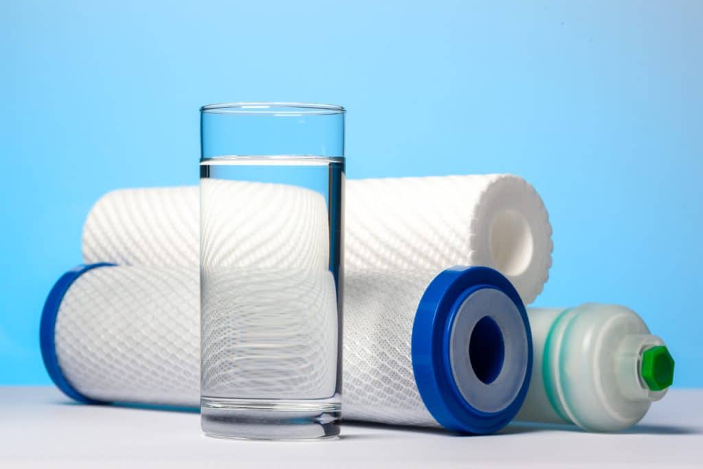 A glass of drinking water and filter cartridges to domestic water treatment systems
